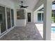 Covered patio with tile flooring, ceiling fan, and views of the backyard and pool area at 261 Broadmoor Ln, Rotonda West, FL 33947