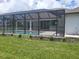 Backyard pool area enclosed with screen, featuring a concrete patio and minimal landscaping at 261 Broadmoor Ln, Rotonda West, FL 33947