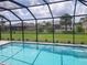 Screened pool with clear blue water, surrounded by green lawn and residential neighborhood views at 261 Broadmoor Ln, Rotonda West, FL 33947