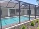 Screened backyard pool with paver deck, surrounded by minimal greenery, offering a private retreat at 261 Broadmoor Ln, Rotonda West, FL 33947