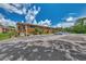 Condo building with parking lot and lush landscaping at 6 Quails Run Blvd # 7, Englewood, FL 34223