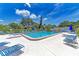 Community pool with lounge chairs and umbrellas at 6 Quails Run Blvd # 7, Englewood, FL 34223