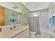 Clean bathroom with shower/tub, sink, and floral wallpaper at 6 Quails Run Blvd # 7, Englewood, FL 34223