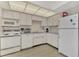 Efficient kitchen with white cabinets and appliances at 6 Quails Run Blvd # 7, Englewood, FL 34223