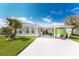 Manufactured home with covered carport and green trailer at 624 Blackburn Blvd, North Port, FL 34287