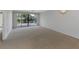 Spacious living room with balcony access and carpet at 53 W Bay Heights Rd # 205, Englewood, FL 34223