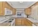 Bright kitchen with granite countertops and wood cabinets at 53 W Bay Heights Rd # 205, Englewood, FL 34223