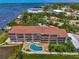 Aerial view of condo building, pool, and waterfront access at 53 W Bay Heights Rd # 205, Englewood, FL 34223