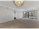 Living room with carpeted floor, balcony access, and fan at 53 W Bay Heights Rd # 205, Englewood, FL 34223