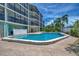 Community pool with adjacent building and lush foliage at 53 W Bay Heights Rd # 205, Englewood, FL 34223