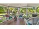 Relaxing front porch with white wicker furniture, offering a peaceful outdoor space at 1730 Padre Ln, Englewood, FL 34223