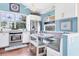 White kitchen with built-in banquette seating and stainless steel appliances at 1730 Padre Ln, Englewood, FL 34223