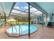 Round pool with wooden deck and screen enclosure at 1730 Padre Ln, Englewood, FL 34223