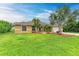 Single-Gathering house with tan exterior, palm trees, and a landscaped yard at 14143 Saul Ln, Port Charlotte, FL 33981