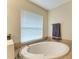 Bathroom featuring a large soaking tub and window at 14143 Saul Ln, Port Charlotte, FL 33981