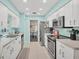 Updated kitchen featuring stainless steel appliances and light blue cabinets at 10168 Willowood Ave, Englewood, FL 34224