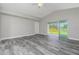 Bright living room with grey wood-look tile floor and sliding glass doors at 13151 Marathon Blvd, Port Charlotte, FL 33981