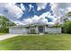 A charming one-story home featuring a two-car garage, arched entryway, and manicured front lawn at 5332 Ulysses St, Port Charlotte, FL 33981