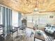 Bright living room with wood-look floors, wood ceiling, and a glass dining table at 208 Marlette Dr, North Port, FL 34287