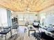 Bright and airy living room with wood ceiling, glass dining table, and comfy seating at 208 Marlette Dr, North Port, FL 34287