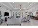 Spacious living room with gray sofas, a large TV, and access to the pool at 283 Long Meadow Ln, Rotonda West, FL 33947
