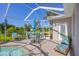 Enjoy the screened patio with pool, seating, and umbrella at 283 Long Meadow Ln, Rotonda West, FL 33947