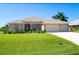 House exterior featuring a two-car garage and well-manicured lawn at 283 Long Meadow Ln, Rotonda West, FL 33947