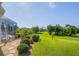 Landscaped backyard with lush lawn, screened enclosure, and mature tropical plants at 283 Long Meadow Ln, Rotonda West, FL 33947