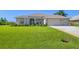 House exterior featuring a two-car garage and well-manicured lawn at 283 Long Meadow Ln, Rotonda West, FL 33947