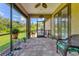 Relaxing screened porch with tiled floor, ceiling fan, and lush green views at 191 Brig W Cir, Placida, FL 33946