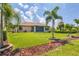 Landscaped backyard with grassy lawn and tropical plants at 191 Brig W Cir, Placida, FL 33946