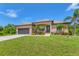 Single-story home with garage, landscaping, and palm trees at 191 Brig W Cir, Placida, FL 33946