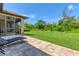 Spacious backyard with grassy lawn, paver patio, and screened porch at 191 Brig W Cir, Placida, FL 33946