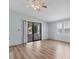 Living room with hardwood floors, ceiling fan, and sliding glass doors at 755 Butterfield Cir, Englewood, FL 34223