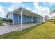 Side view of a light blue manufactured home with covered patio at 740 Summersea Ct, Englewood, FL 34223