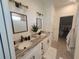 Bathroom with double sinks, granite countertop, and walk-in closet at 9174 Bensonhurst Ln, Englewood, FL 34224