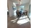 Bright dining room with a round table and four chairs, near sliding doors at 9174 Bensonhurst Ln, Englewood, FL 34224