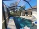Enclosed rectangular pool with patio furniture and a covered lanai at 9174 Bensonhurst Ln, Englewood, FL 34224
