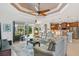 Spacious living room with light leather sofas, a large TV, and access to a pool and patio at 15964 Viscount Cir, Port Charlotte, FL 33981