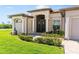 Inviting exterior featuring a well-maintained lawn, attractive landscaping, and a grand entrance at 15964 Viscount Cir, Port Charlotte, FL 33981