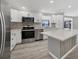 Modern kitchen with white cabinets, quartz countertops, and stainless steel appliances at 740 Summersea Ct, Englewood, FL 34223