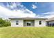 Single-story home with grassy backyard and patio at 213 Antis Dr, Rotonda West, FL 33947
