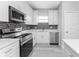 White kitchen with stainless steel appliances and mosaic backsplash at 213 Antis Dr, Rotonda West, FL 33947