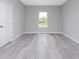 Bright bedroom with grey vinyl flooring, white door and window with backyard view at 213 Antis Dr, Rotonda West, FL 33947