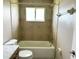 Well-lit bathroom featuring tile walls and flooring with a shower and tub combo at 35 Mark Twain Ln, Rotonda West, FL 33947