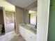Bathroom featuring dual sinks, tiled flooring, and a walk-in shower at 35 Mark Twain Ln, Rotonda West, FL 33947