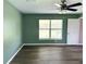 A naturally lit bedroom featuring a ceiling fan, dark hardwood floors, and green walls at 35 Mark Twain Ln, Rotonda West, FL 33947