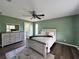 Comfortable bedroom with a ceiling fan, dresser, and a view into the bathroom at 35 Mark Twain Ln, Rotonda West, FL 33947