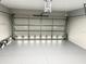 Spacious garage featuring an automatic garage door and painted floors at 35 Mark Twain Ln, Rotonda West, FL 33947