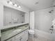 All-white bathroom with a green marble countertop and white subway tiled shower and bath at 6000 Boca Grande Cswy # D46, Boca Grande, FL 33921